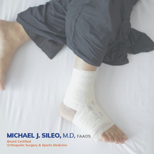 no fault orthopedic doctor in east setauket A person's foot and lower leg wrapped in a white bandage, resting on a bed; text indicates Michael J Sileo, M D , an orthopedic surgery and sports medicine specialist
